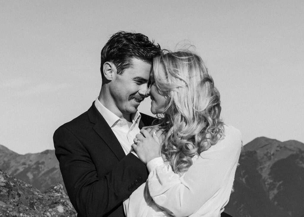 a black and white image of a bride and groom embracing, their foreheads press against each other 