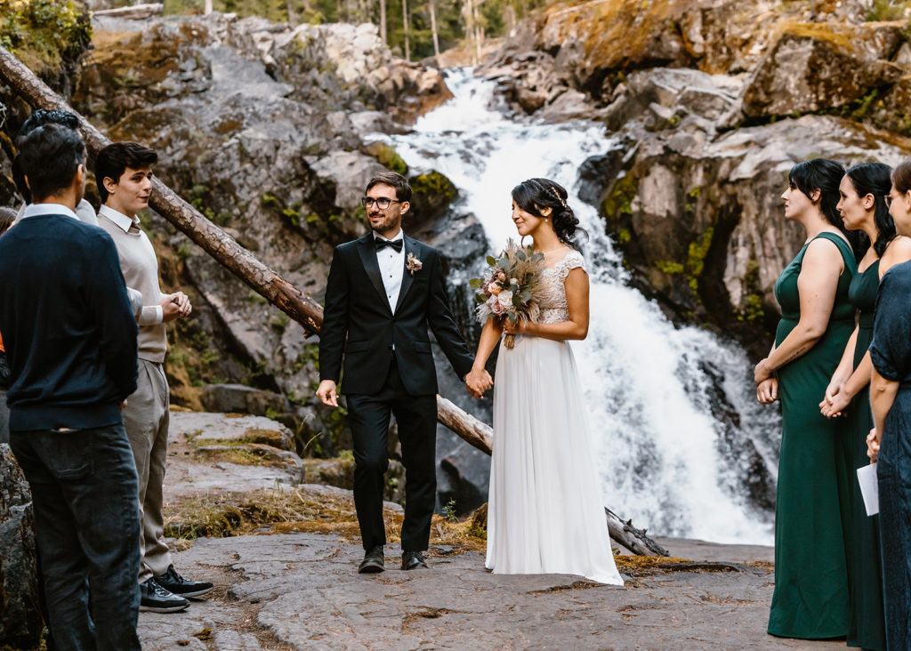 bride and groom smile as the groomsmen sing at their mt. rainier elopement