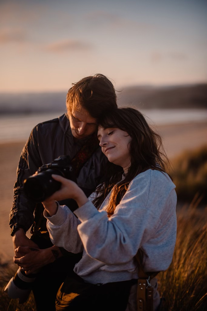 last minute elopement photographers snuggle up gazing at the images on the back of their cameras 