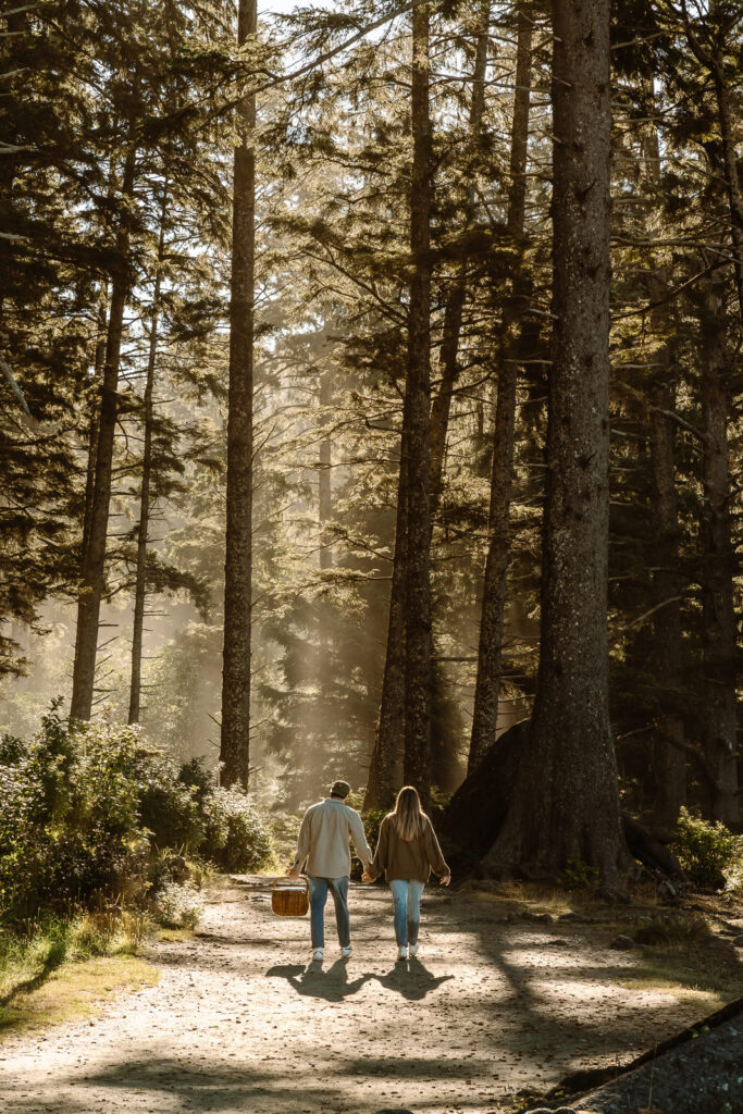 On the morning of their coastal elopement, a bride and groom explore a coastal rainforest as a hazy sunrise sets the tone for their day.