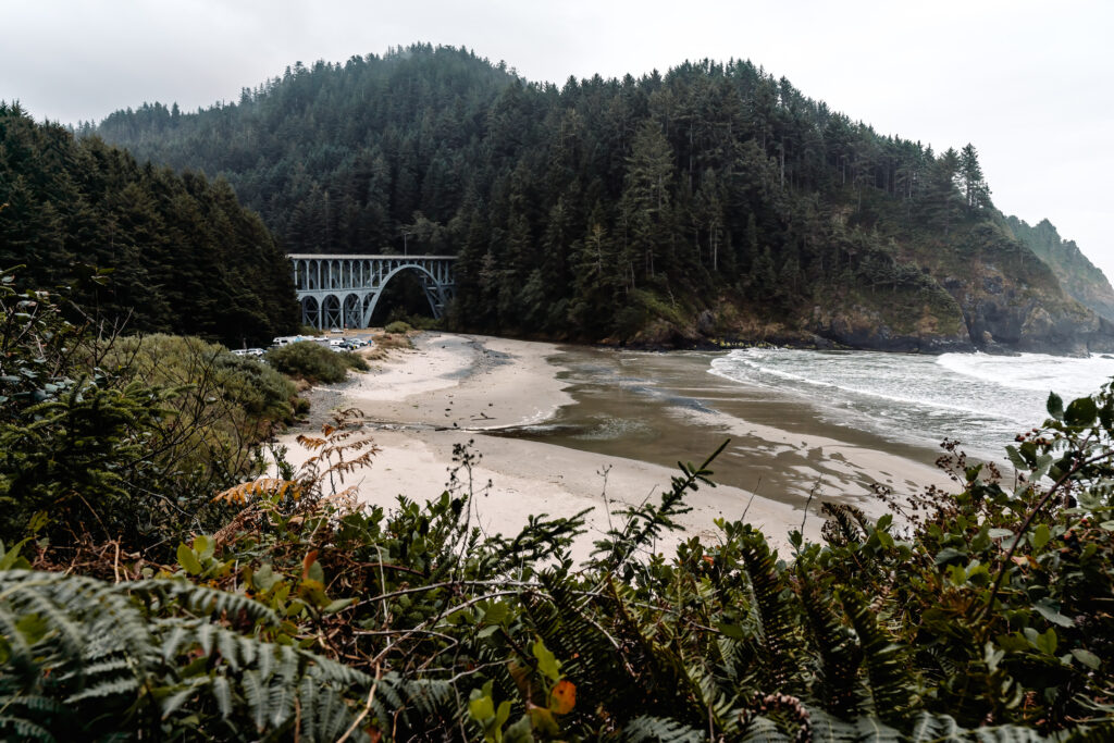 A story telling shot of the moody beach with an iron bridge where this surfer wedding will take placce