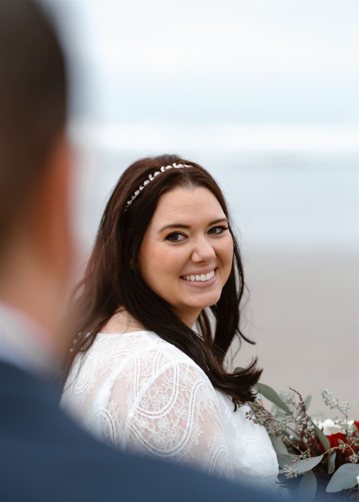 a perspective shot of a bride gazing lovingly at her groom. her face is in focus and is framed by his silhouette during their pacific coast wedding