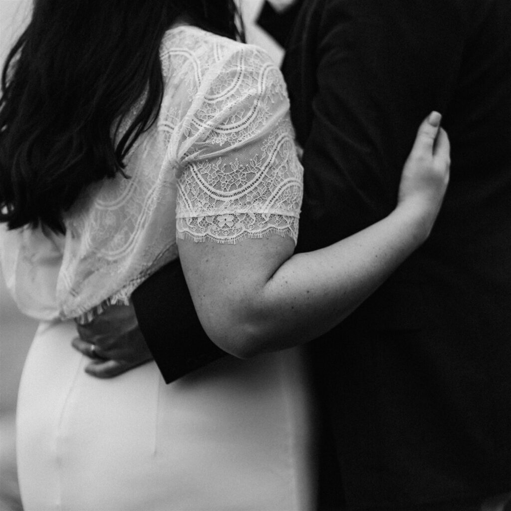 a close up shot of a bride and groom interlacing their arms