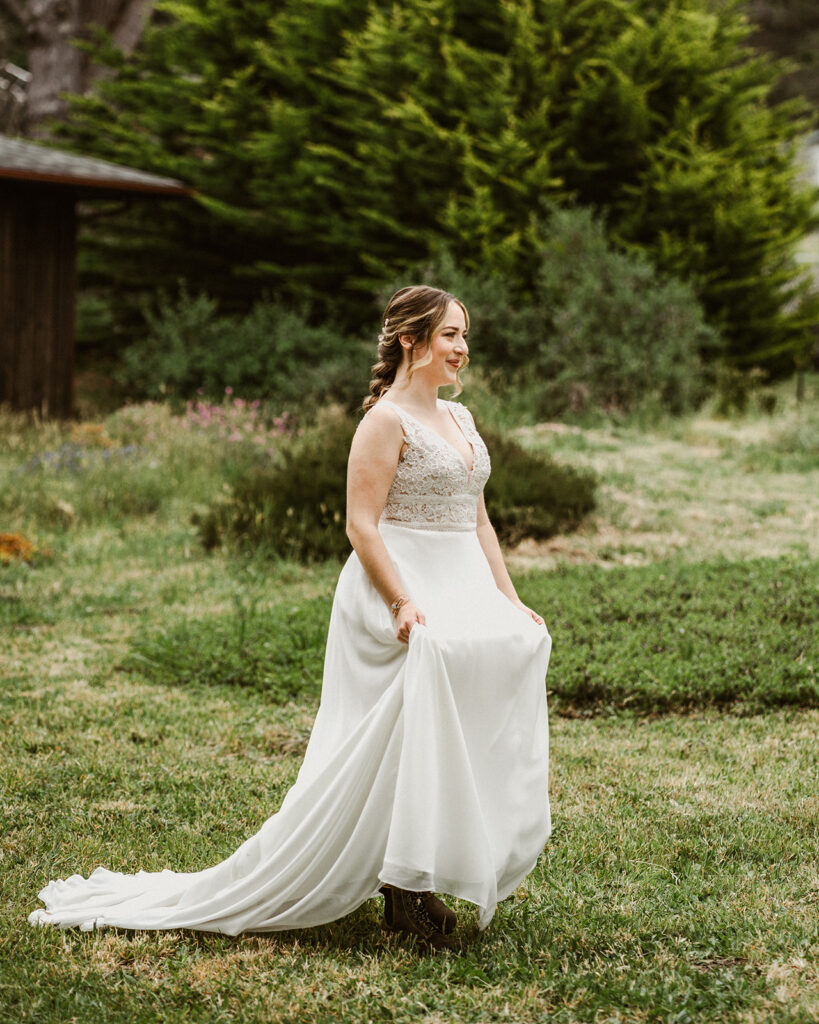 A smiling bride walks through the garden.