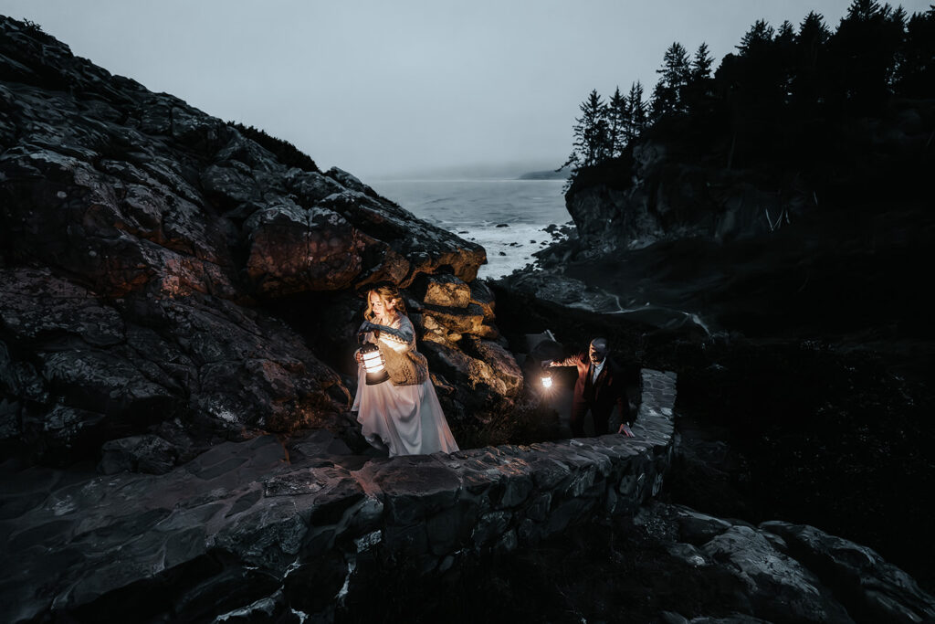 A bride leads the way up an old stone staircase. She holds a lantern as she explores and her groom follows