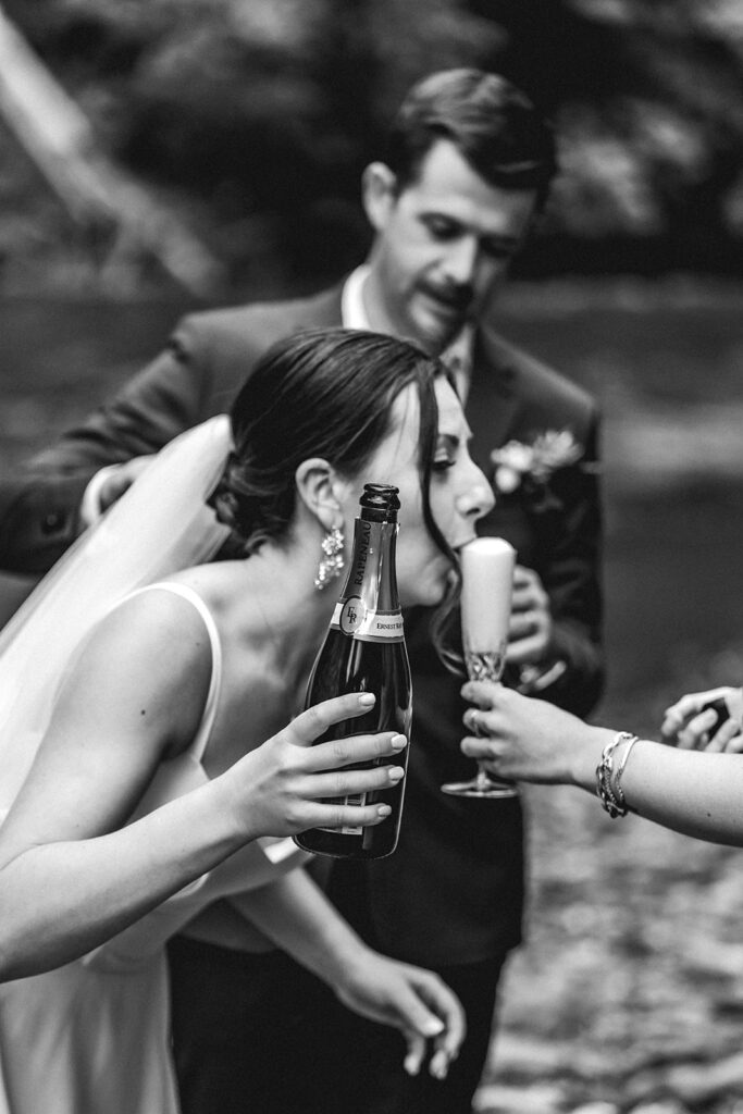 to celebrate their backpacking wedding, a bride sips the foam of a champagne pour