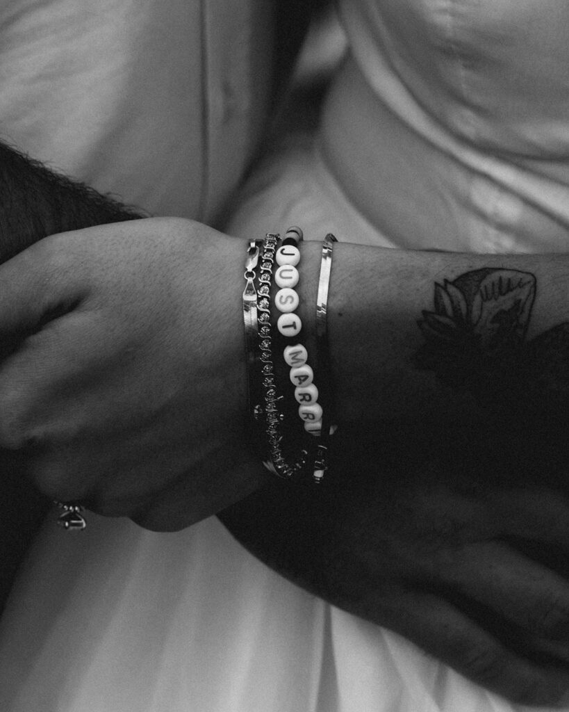 a black and white detail shot of a handmade friendship bracelet that reads "just married" made by the bride for her north cascades elopement