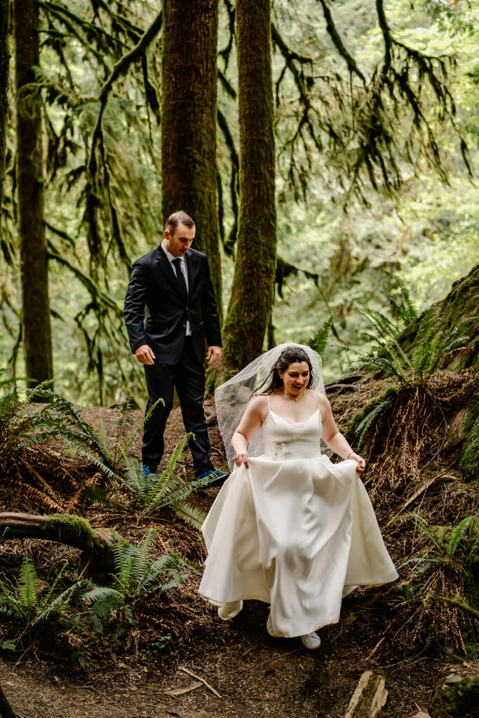 a bride and groom explore a verdant forest in their wedding attire 