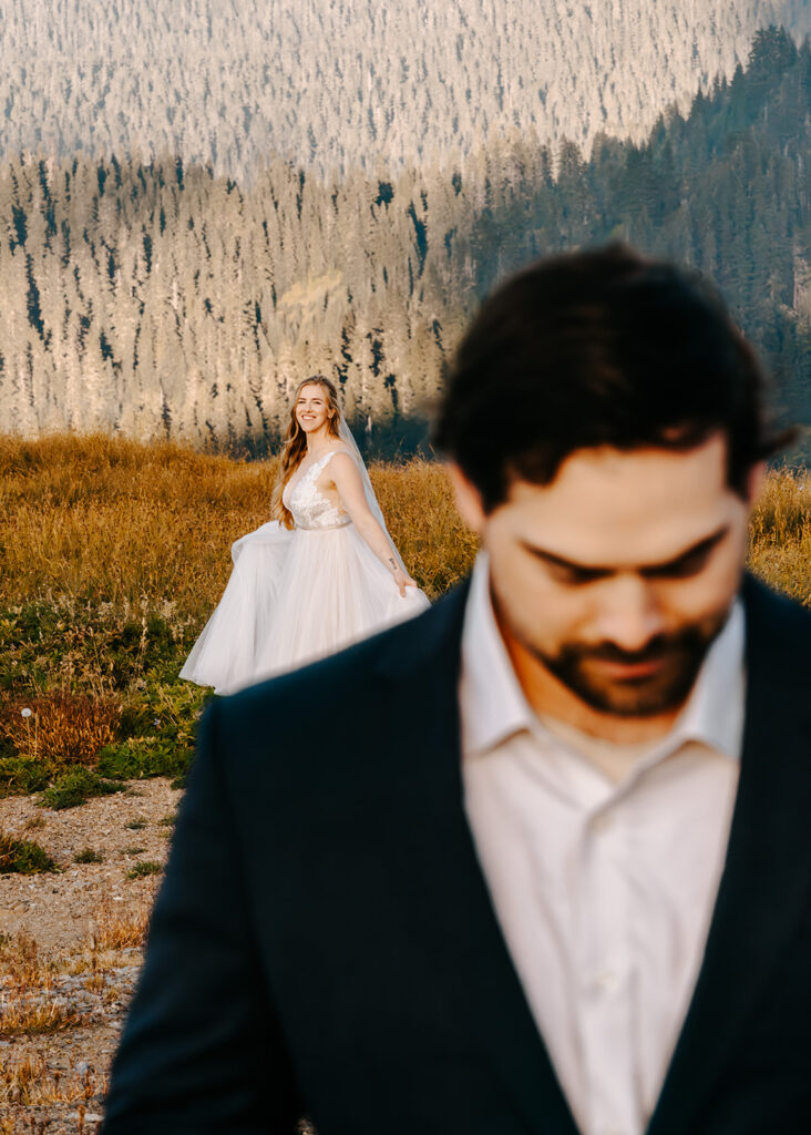 a groom read over his vows, his bride gazes at him lovingly over his shoulder