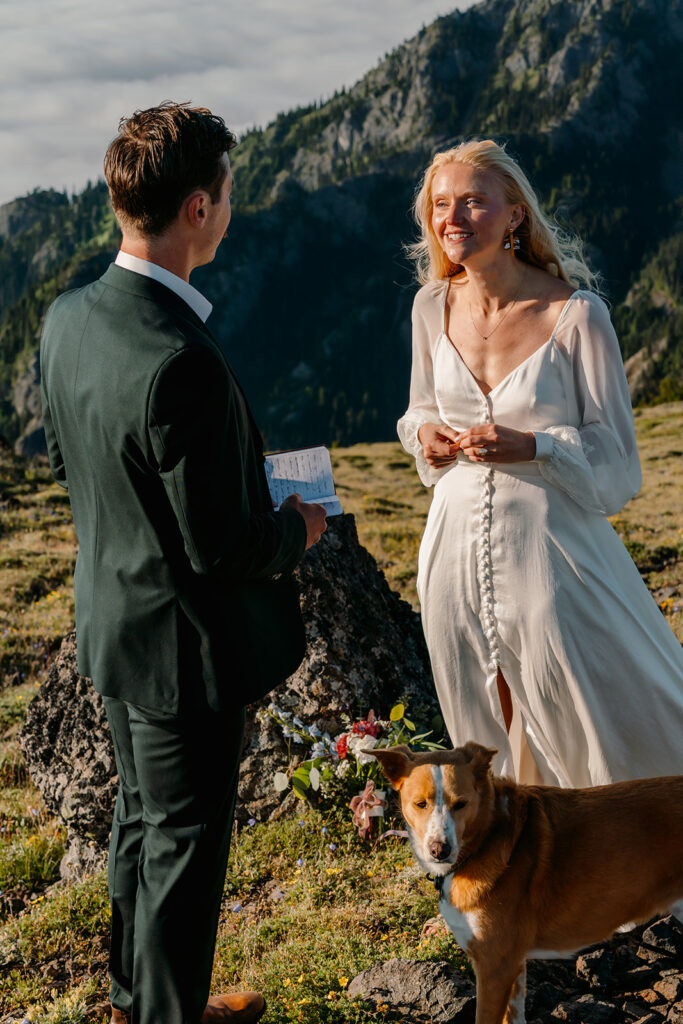a bride smiles widely as her groom reads his vows during their Olympic Peninsula elopement. 
