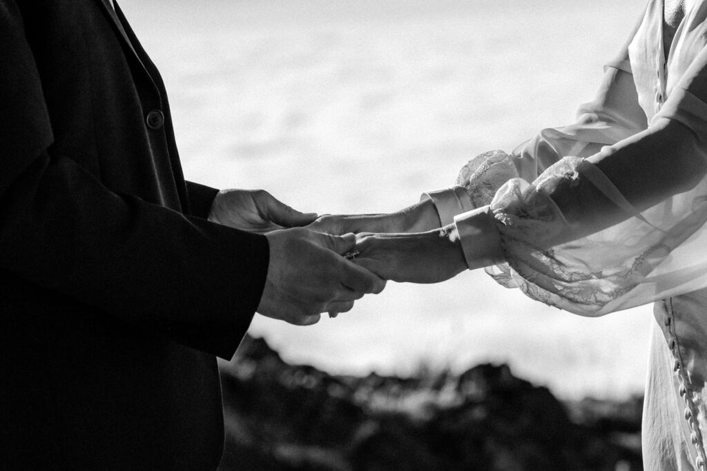 a close up shot of hands embracing in front of a cloud inversion 