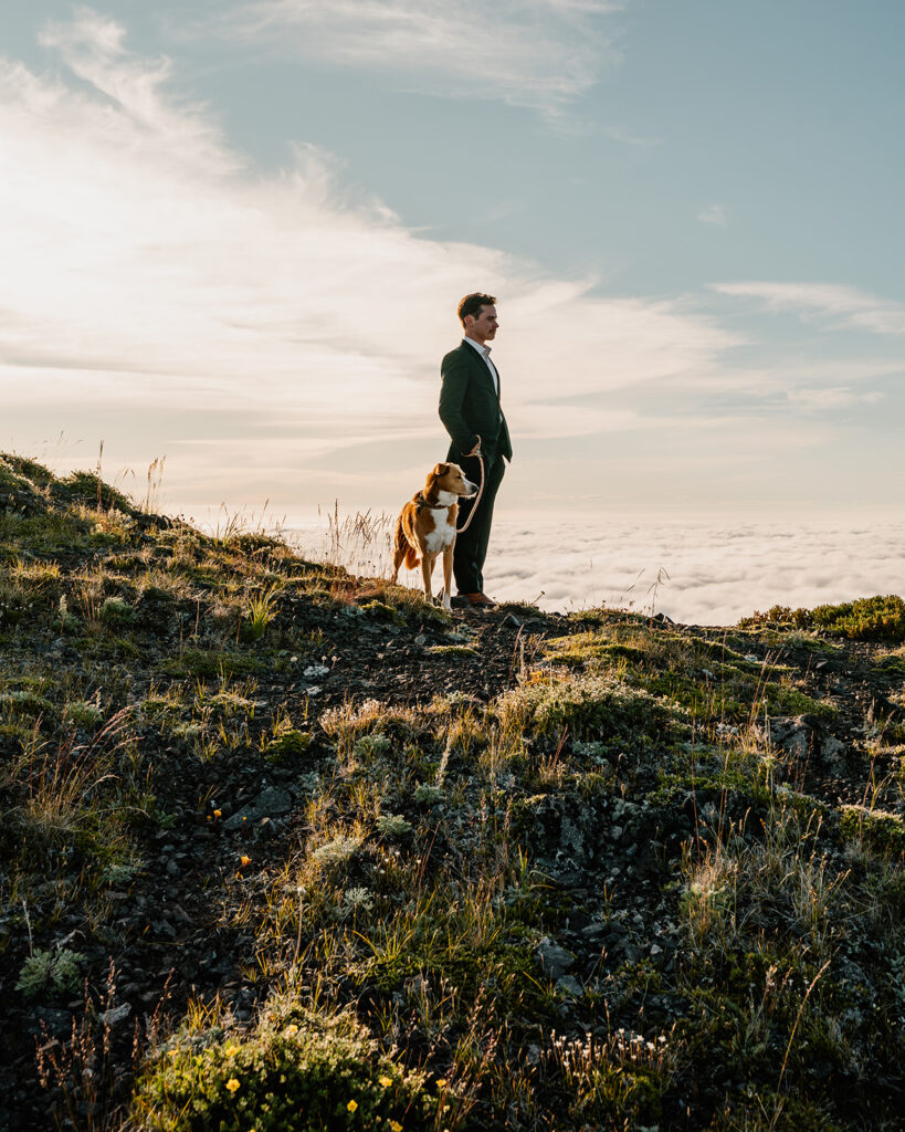 a groom and his dog wait patiently for the bride to crest the switchback for their first look during their Olympic Peninsula elopement. 
