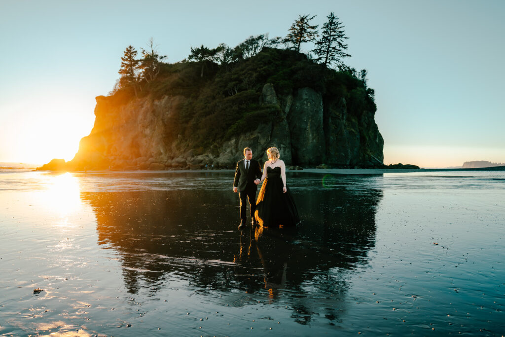 a couple in all black wedding attire explore a rocky beach during a punchy sunset to end their Olympic National Park wedding 