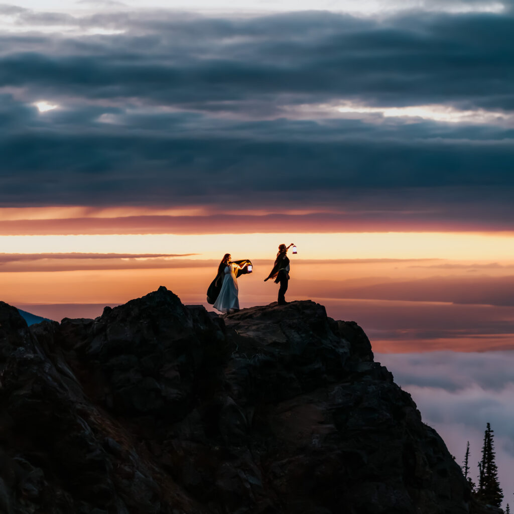 A bride and groom explore a mountains edge by lantern light in the final glow of the sunset during their Olympic National Park wedding 