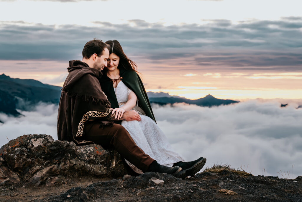 A couple embrace in their wedding attire, seemingly on top of the world one of the best places to elope in Washington. A cloud inversion floats beneath them as they snuggle. 