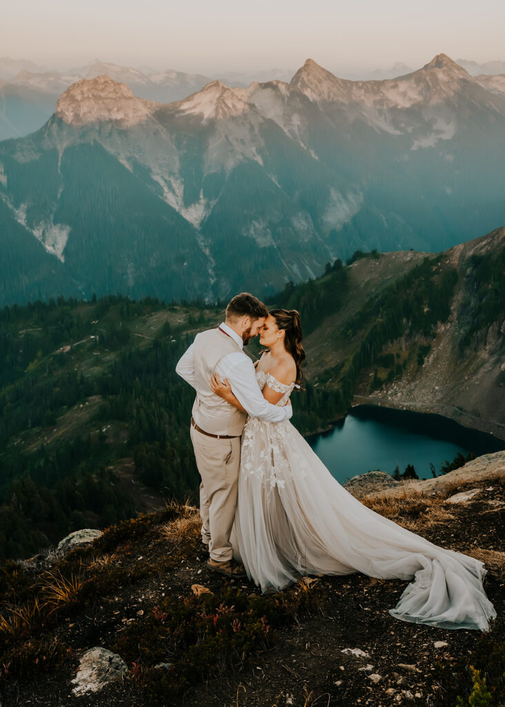 a couple embrace in their wedding attire on top of a mountain, one of the many best places to elope in Washington