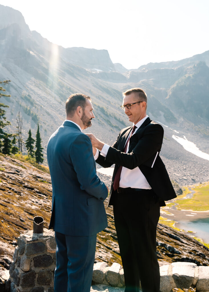 the grooms brother takes a moment to help the groom straighten his tie before the ceremony of this mt baker micro wedding begins