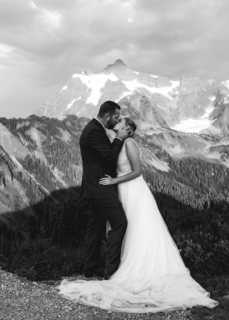 a groom holds his brides face as he pulls her in for a deep kiss during their mt baker micro wedding 