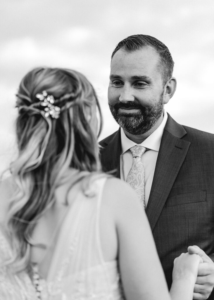 a shot taken over the brides shoulder shows a loving stare from her groom. The moment feels intimate and full