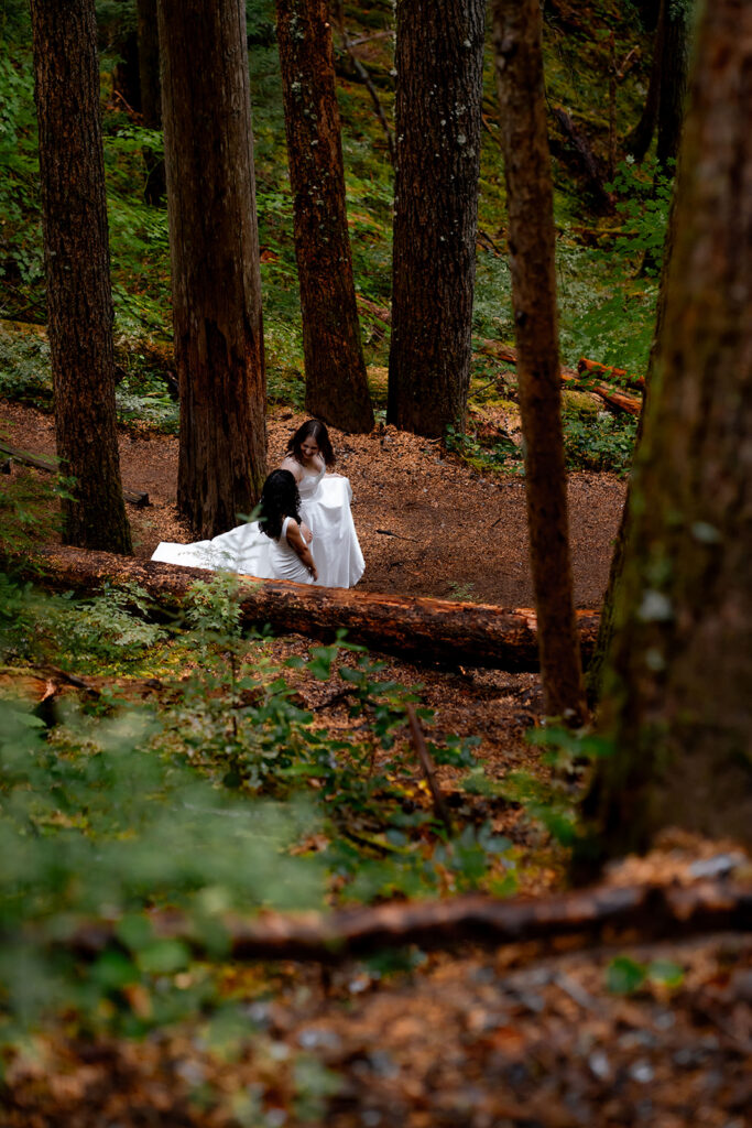 shot from above, two brides hike a dirt trail 