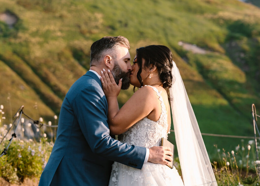 a bride and groom kiss in a field of wildflowers