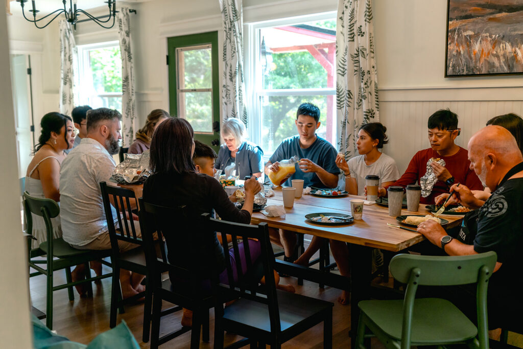 a family sits around a dining table as they share breakfast together