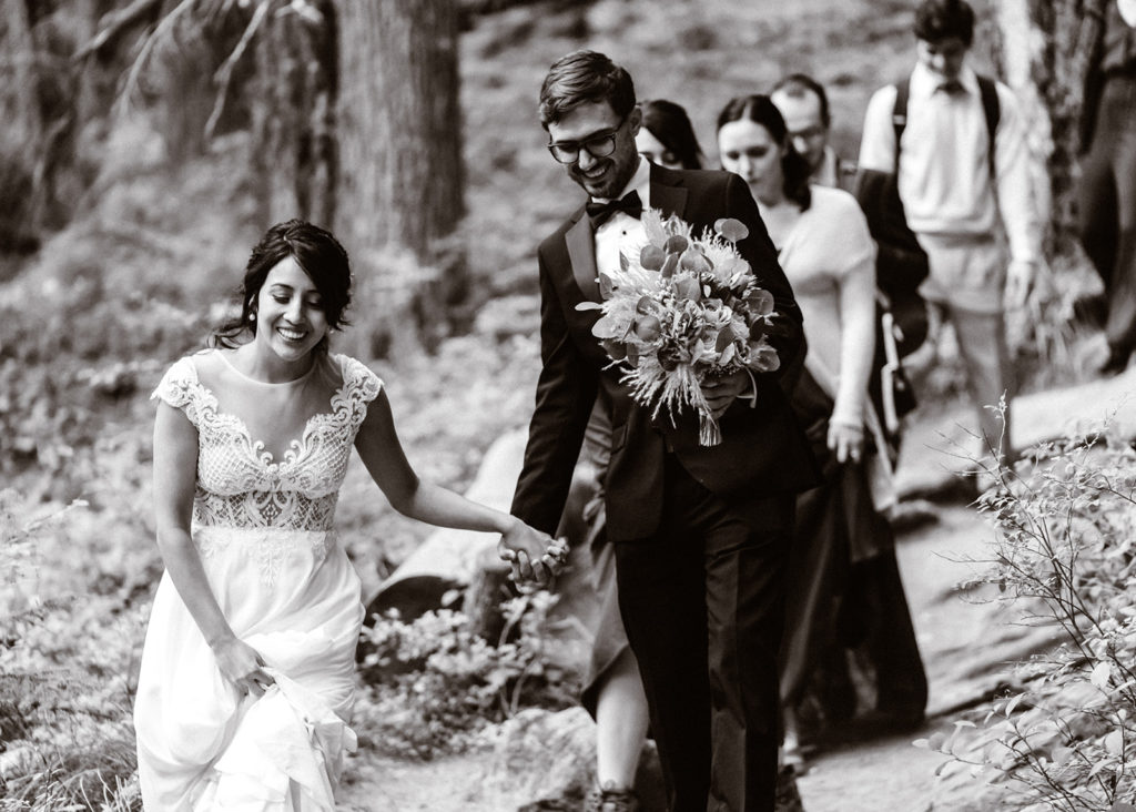 mt rainier wedding party makes their way to the ceremony location on the wooded trail