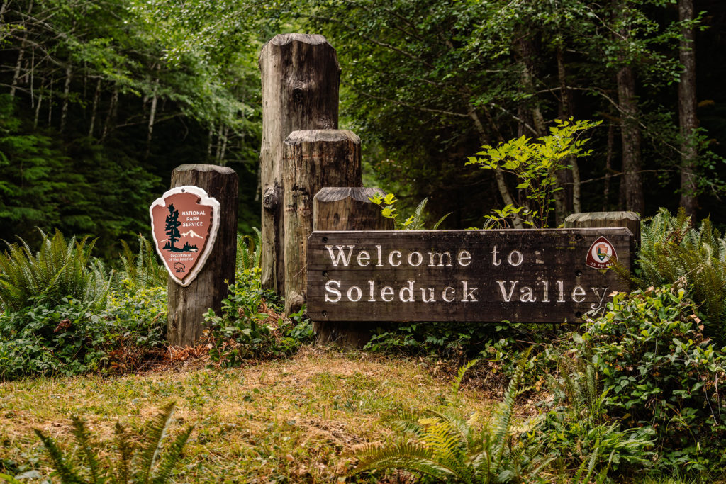 A sign welcoming visitors to Soelduck Valley taken from the couples perspective during their Olympic National Park Elopement
