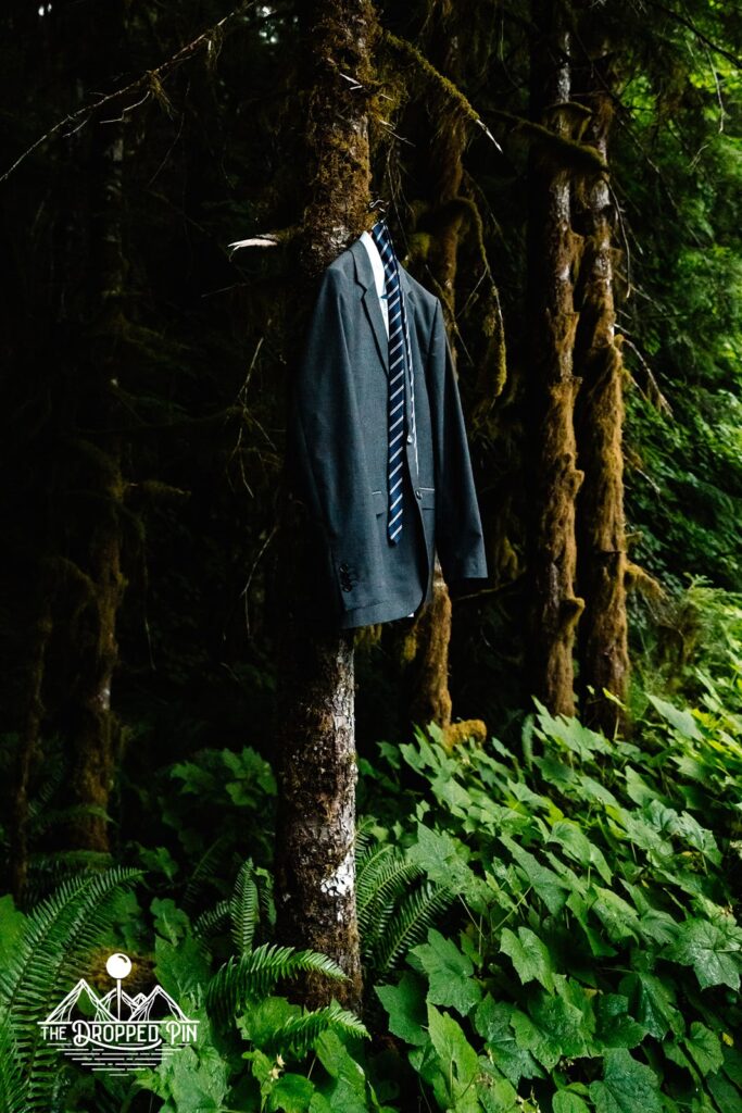 A suit hangs on a tree in the forest waiting to be worn during the Washington elopement