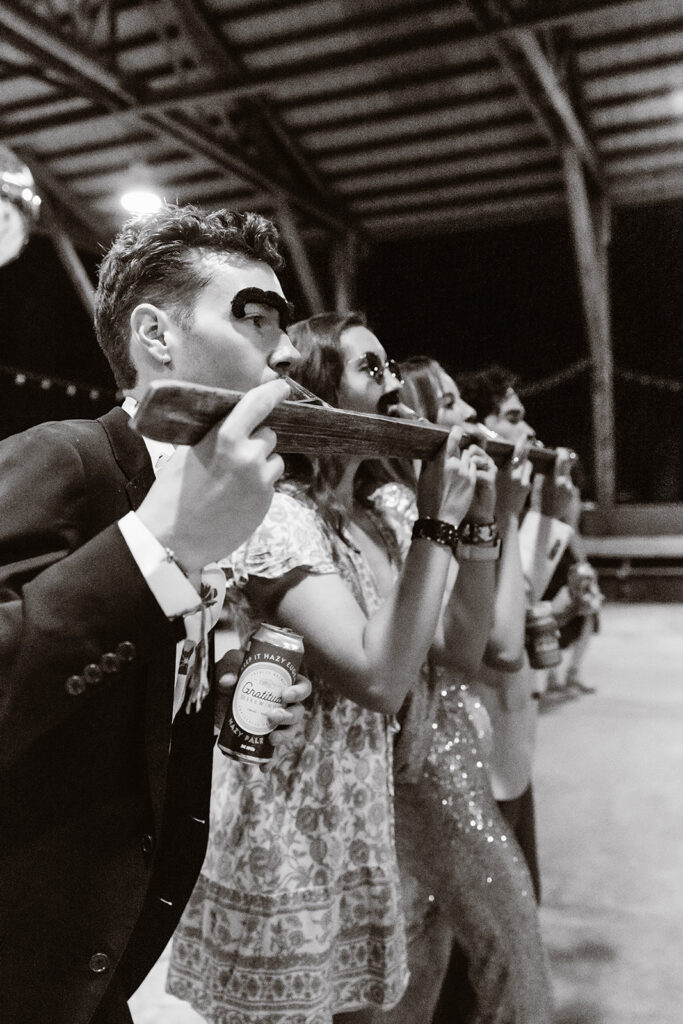 in their elopement timeline, a couple makes time to celebrate with their guests. The bride and guests hold a shot ski.