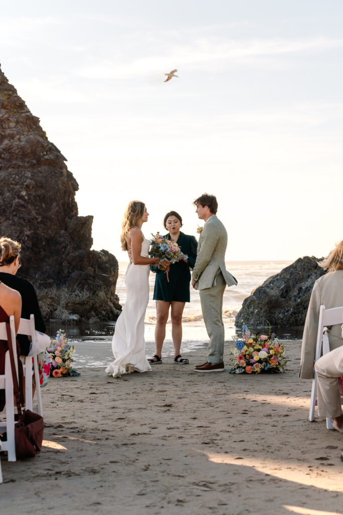 an officiant leads the service of this bride and grooms coastal elopement