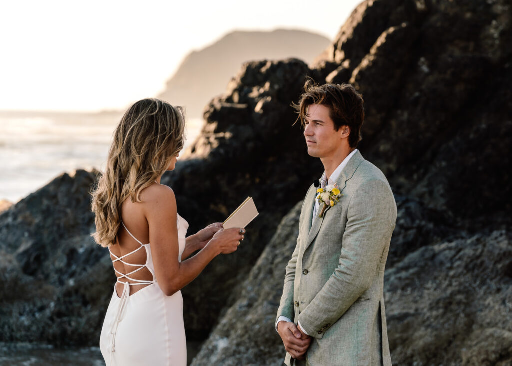 a bride reads vows to her groom during their coastal elopement
