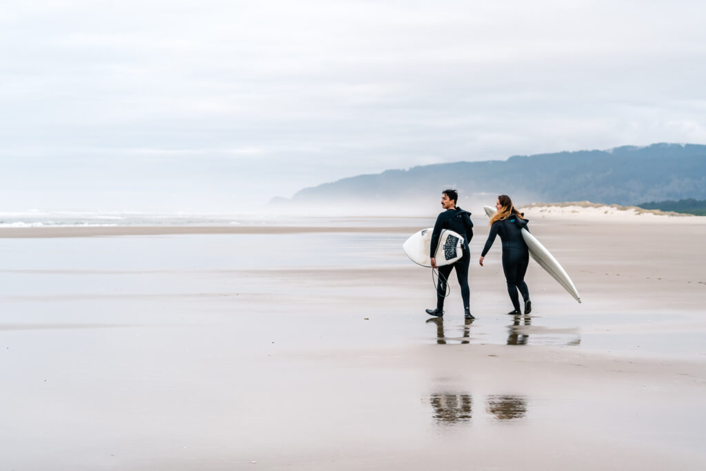 During their surfer wedding, a couple heads towards the surf with their boards.