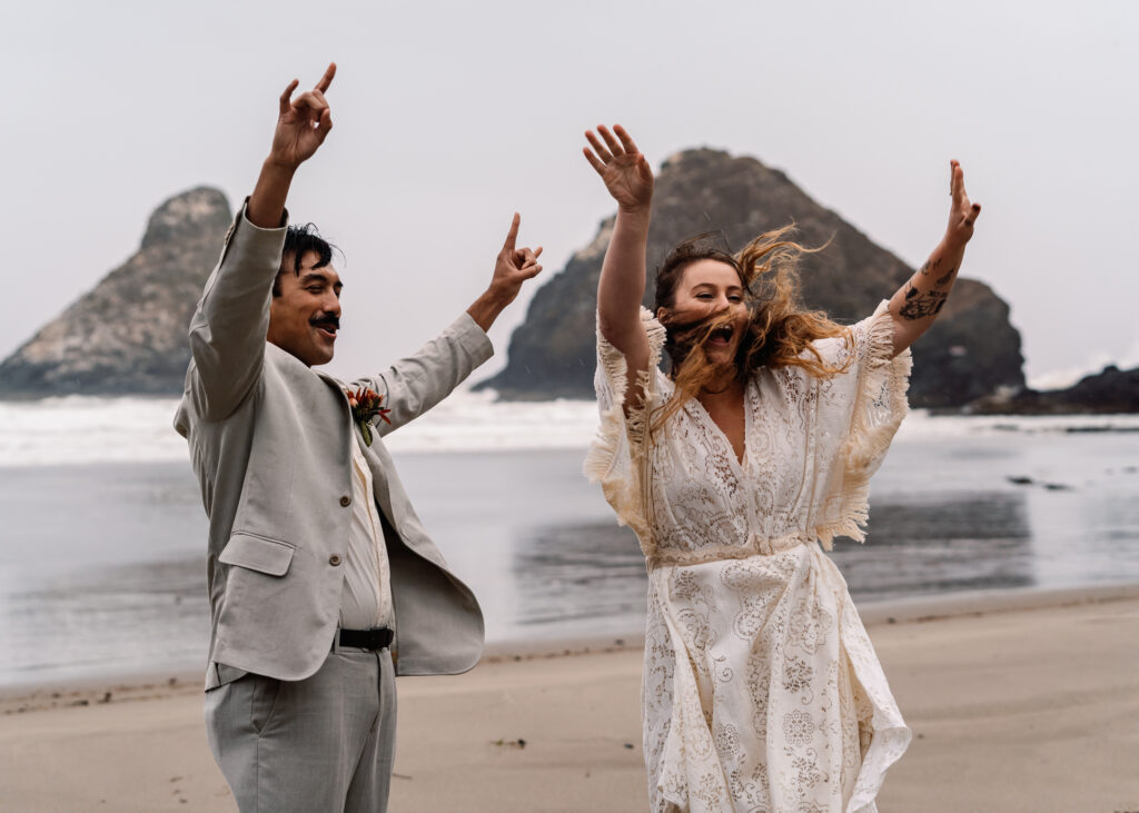 Joy exudes from this couple after they are pronounced married after their surfer wedding. They jump, shout, and throw their hands up in celebration. 