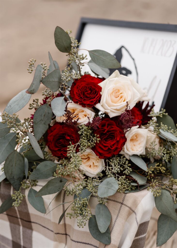 a detail shot of the red and white roses of this romantic pacific coast wedding bouquet.