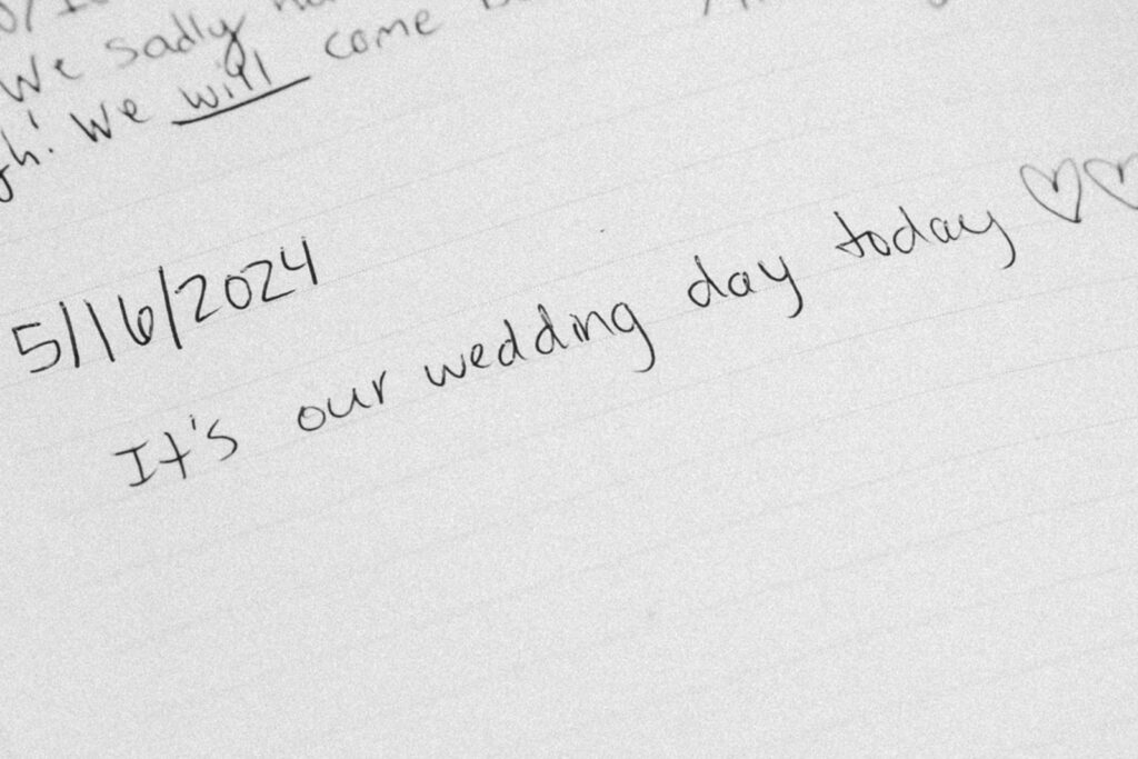 A wide shot of a a guestbook signature, dated 5/16/2024 with the note "It's our wedding day today". Scribbled hearts surround the written text.