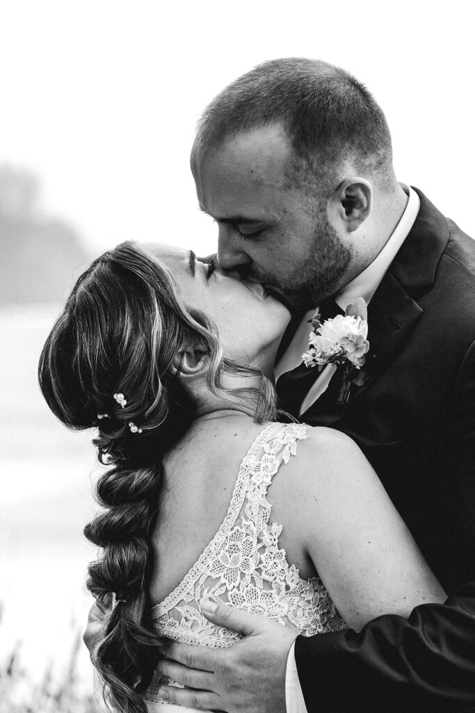 a black and white photo og the bride and groom kissing 