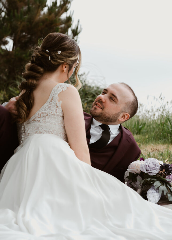 during a picnic, a bride and groom gaze lovingly at each other. 