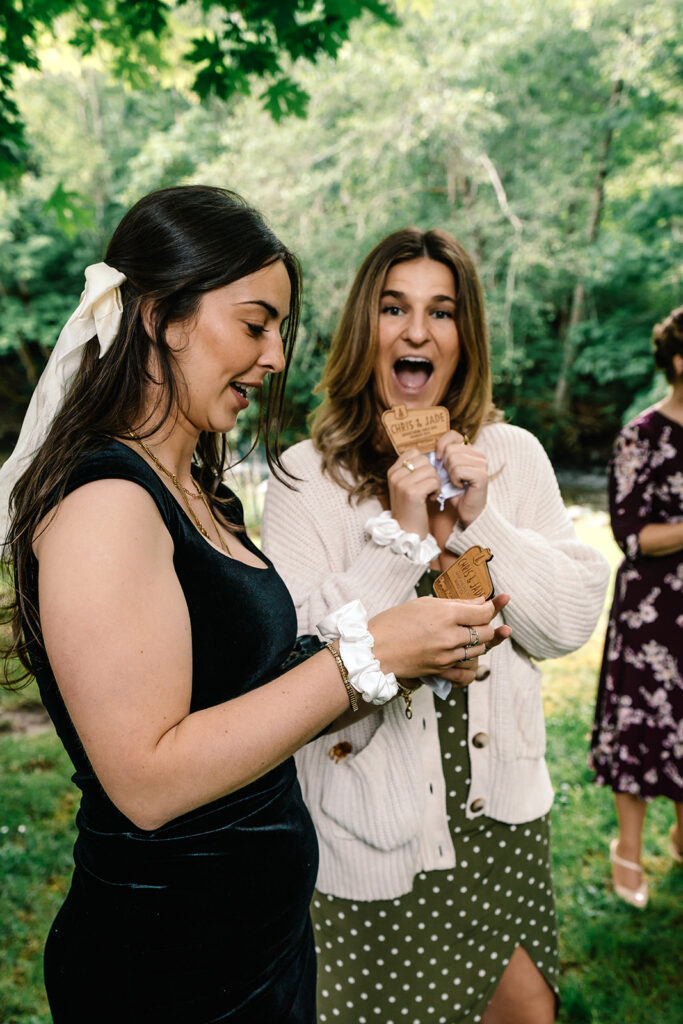 guests smile and hold up gifts from the couple as a thank you for celebrating with them during their backpacking elopement