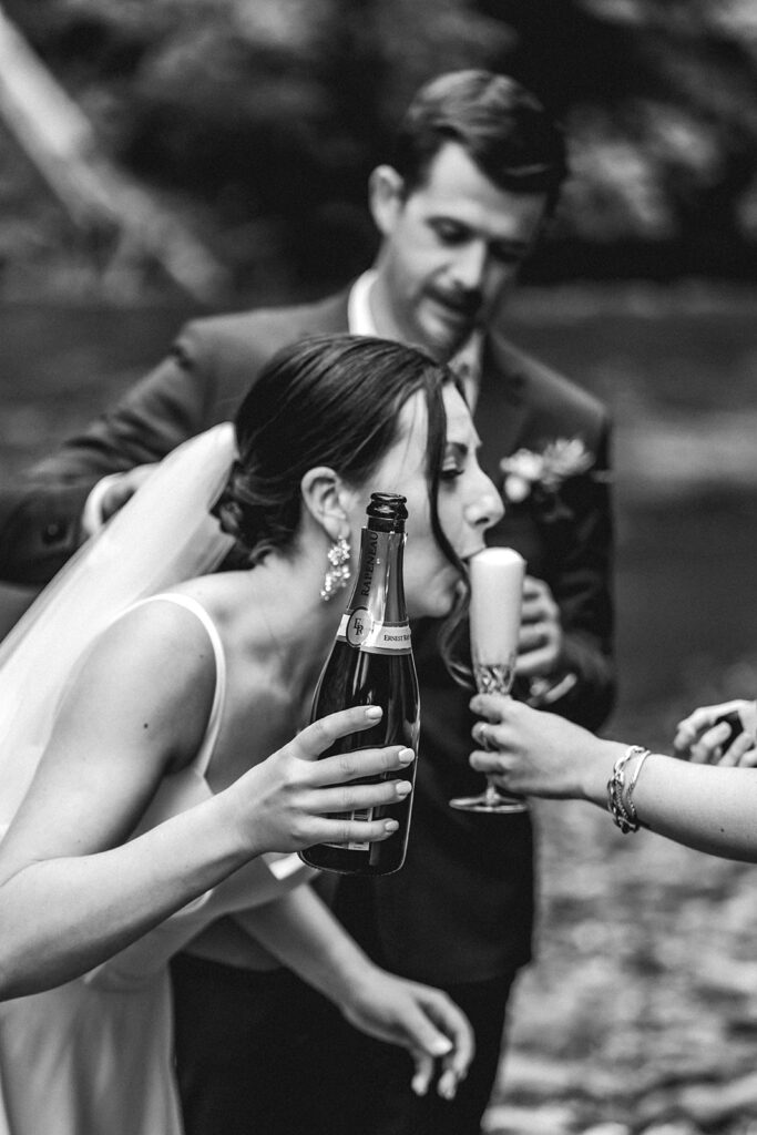 to celebrate their backpacking wedding, a bride sips the foam of a champagne pour