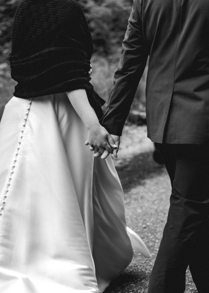 a shot focused on the hands of a bride and groom hiking during their backpacking wedding 