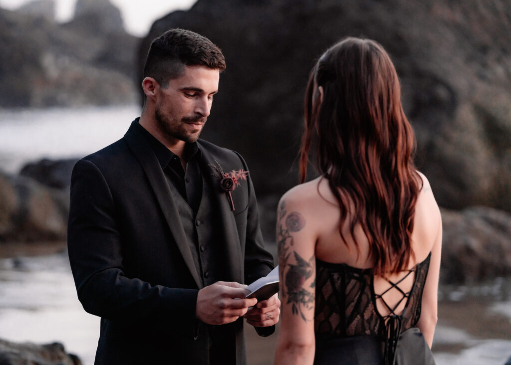 a groom reads from his vow book during his elopement ceremony