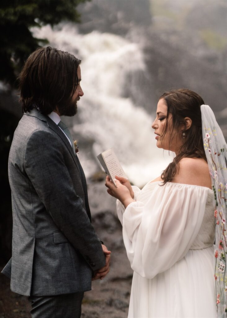 Couple in their wedding attire exchange vows during their sunrise elopement.