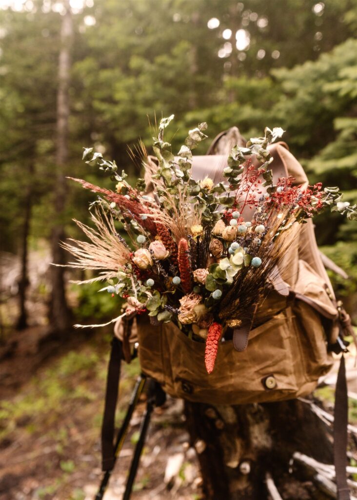 a shot of a colorful, dried bouquet nestled in a canvas backpack. A sweet detail from this sunrise elopement