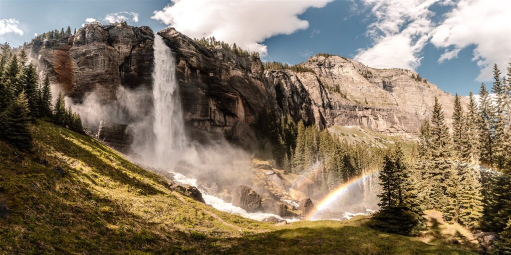 A wide shot of the landscape from this sunrise elopement. Gushing falls, mountains, and gorgeous trees make up the landscape.