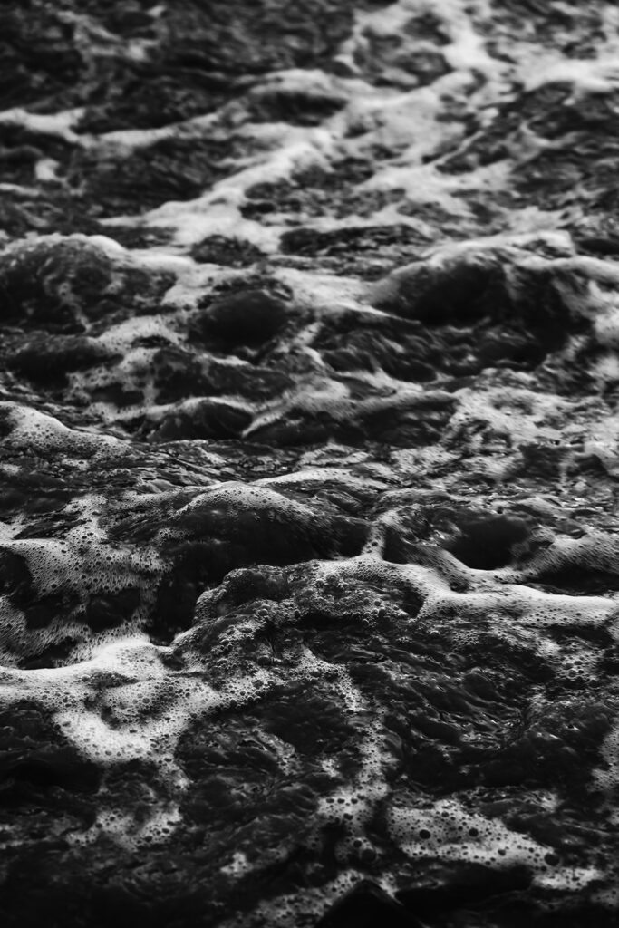 a black and white photo of the rolling ocean waves