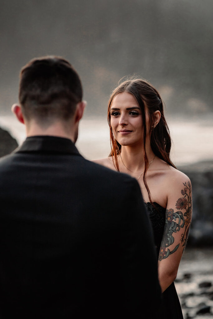 a bride smiles softly as she gazes at her groom during their pacific northwest elopement