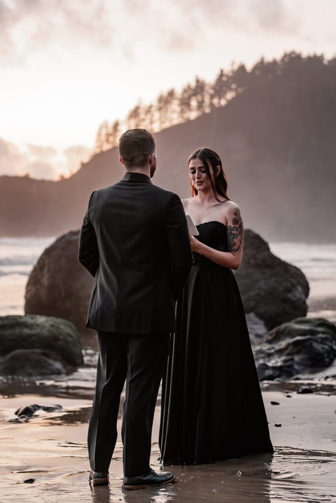 a bride reads her vows to her groom on a moody beach during their pacific northwest elopement