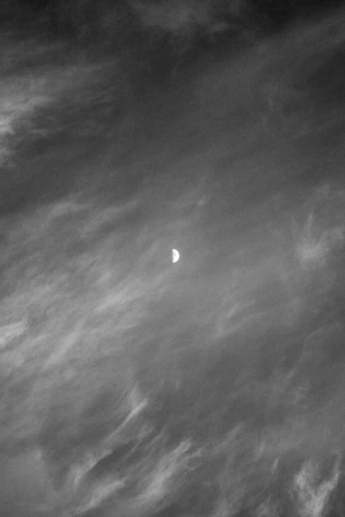 a shot of a waxing crescent moon smeared with wispy clouds