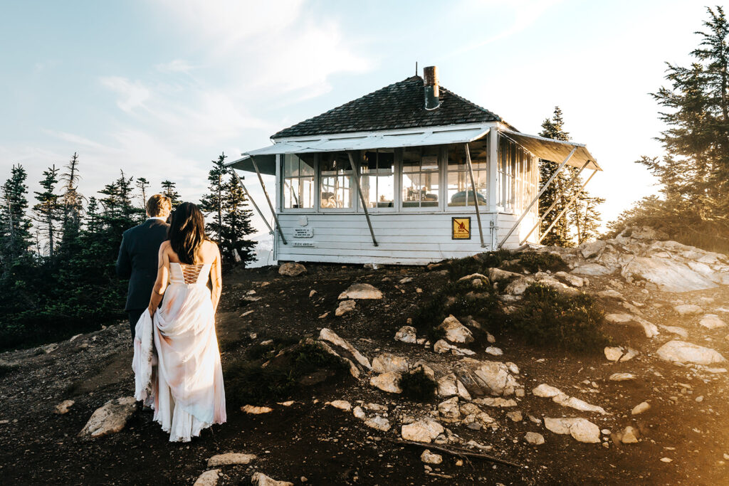 during their hiking elopement, a bride and groom explore a fire tower 